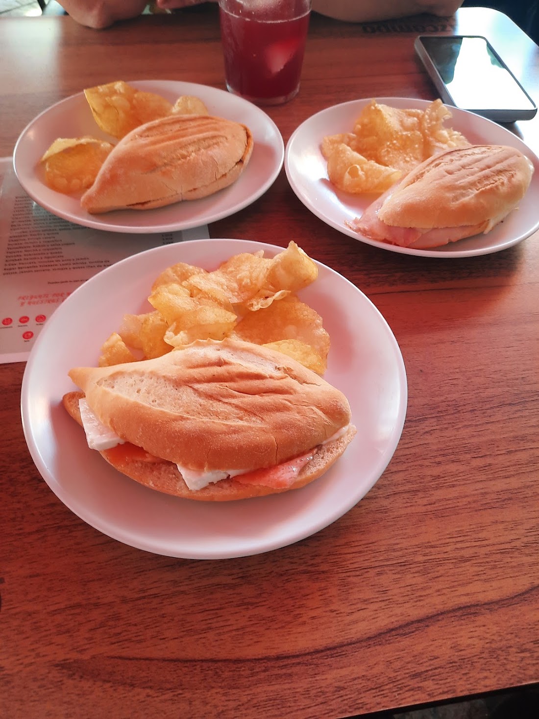 Varios bocadillos con patatas fritas en platos blancos
