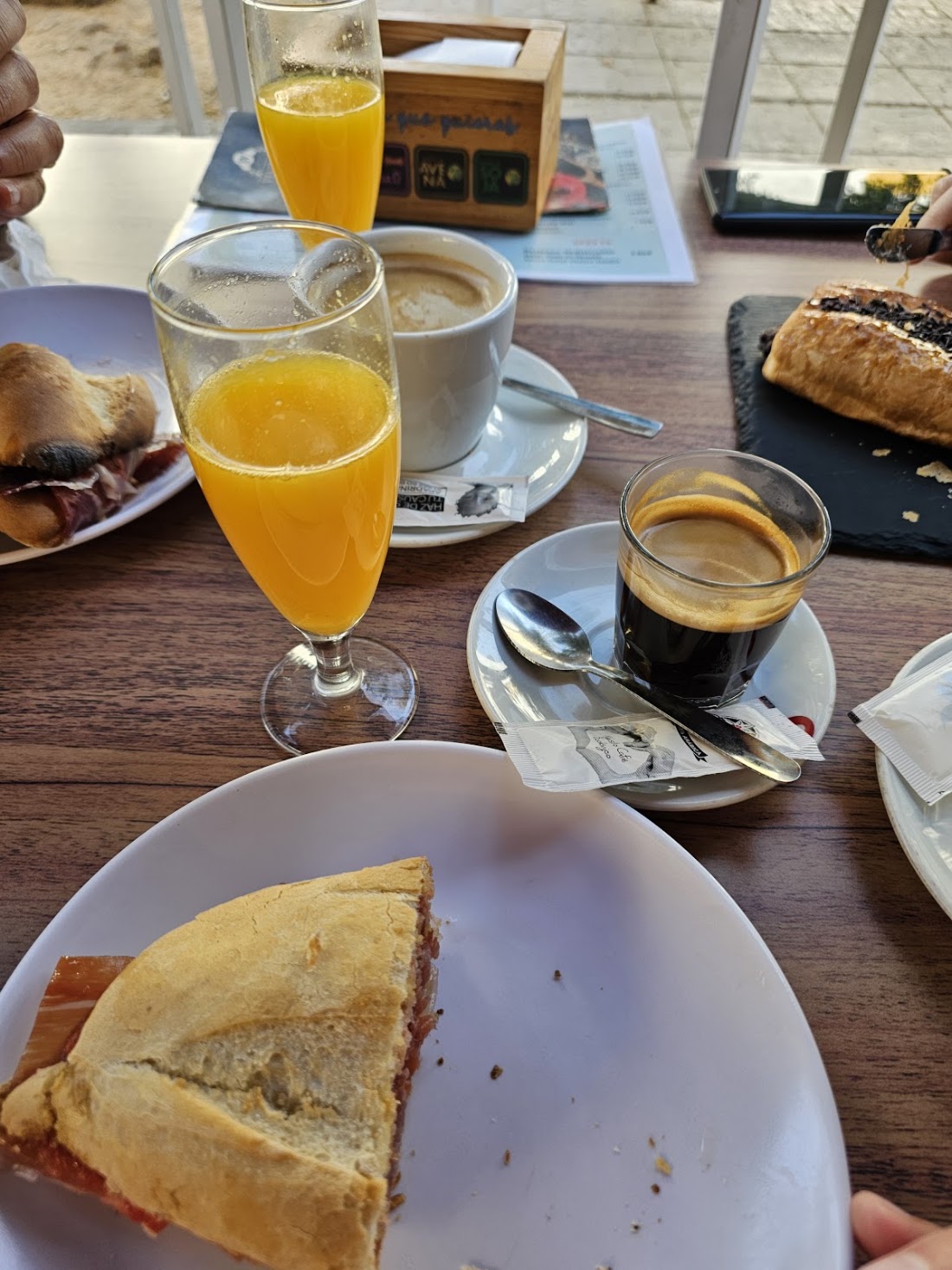 Desayuno con zumo de naranja, café y tostada en la terraza
